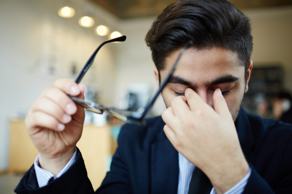 a man holding glasses to his face