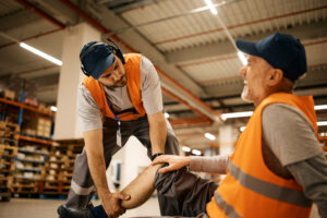 a man in orange vests holding a knee